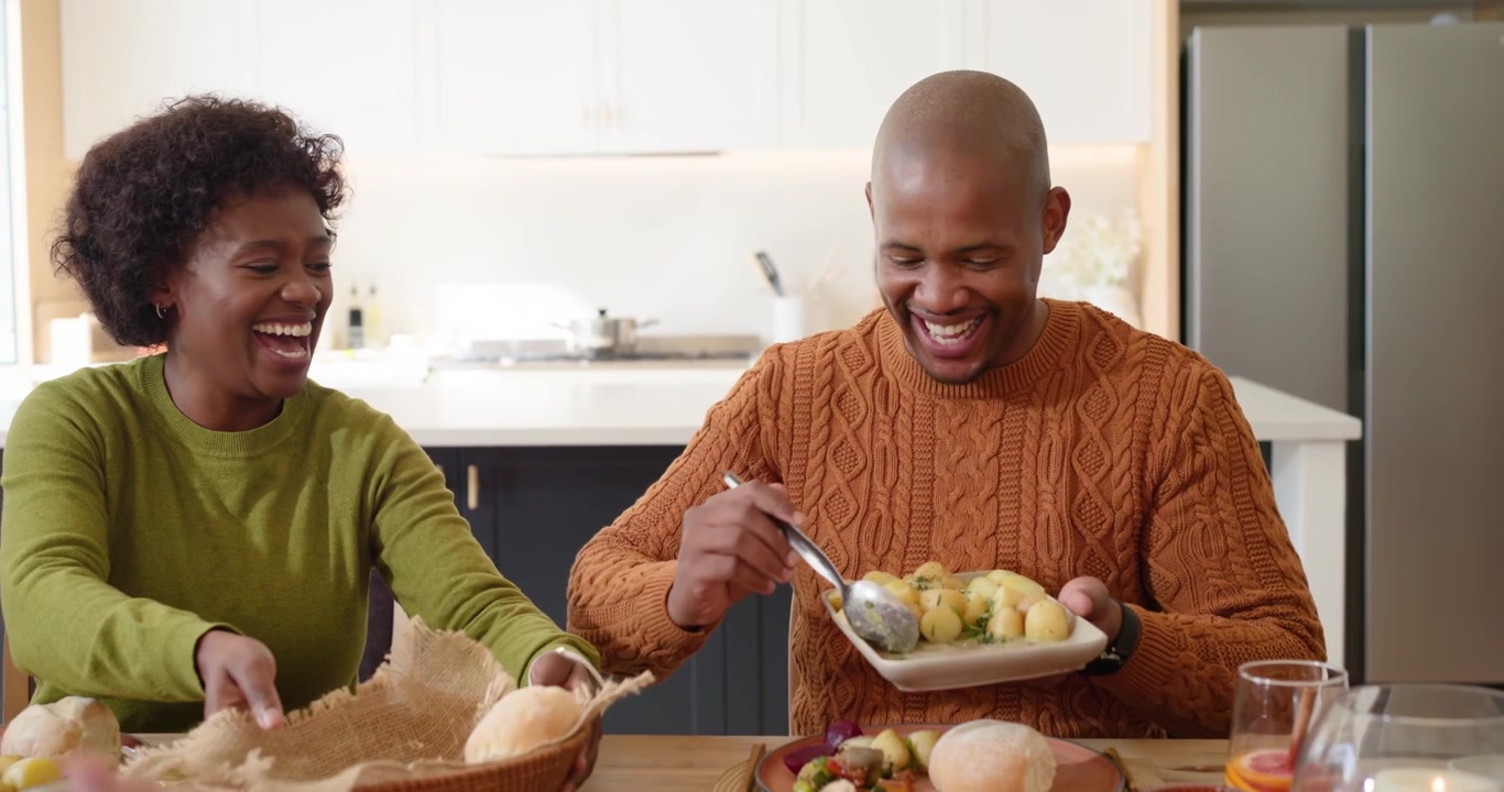 Diverse Group of Friends Laughing Together During Thanksgiving Dinner