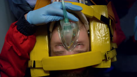 paramedics proving first aid help to man. doctors putting oxygen mask on patient