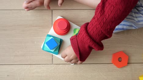 child playing with wooden shape puzzles
