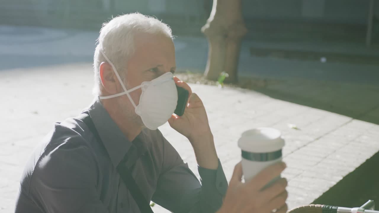 코로나바이러스에 대한 얼굴 마스크를 착용한 백인 남자가 거리에서 돌아다니고 있습니다.
