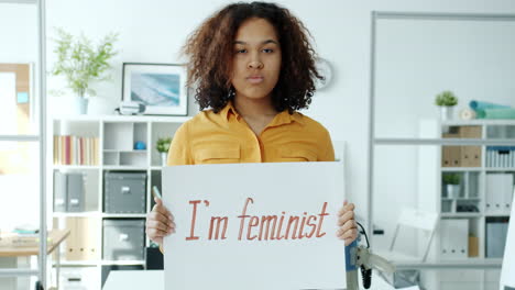 teenager holding sign saying i'm feminist