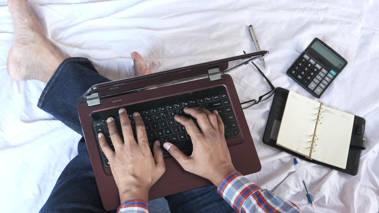 человек, работающий на ноутбуке на кровати