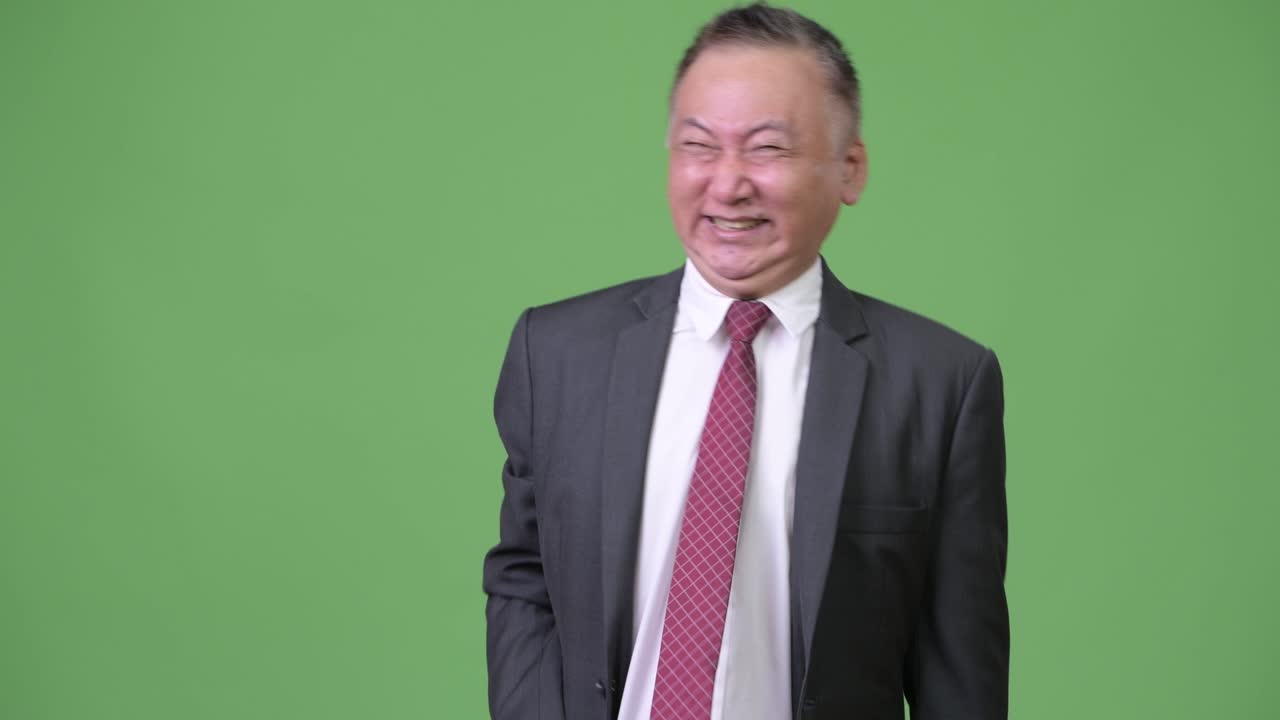 성숙 한 일본인 사업가 가 큰 소리 로 웃고 있다