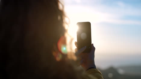 frau, die ein foto von sonnenaufgang oder sonnenuntergang macht