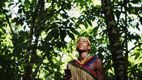 african boy using smartphone in the jungle