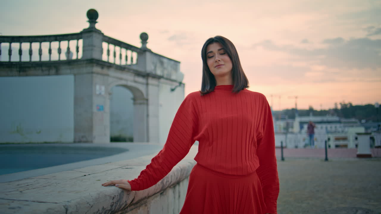 Sensual brunette looking camera strolling city landmark walking sunset closeup