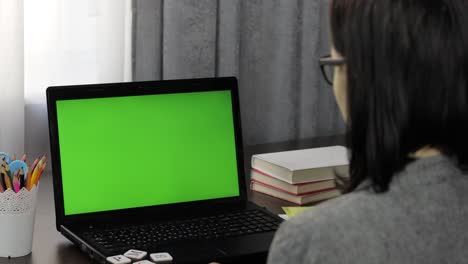 Woman-teacher-making-online-distance-education-video-call-on-laptop-green-screen