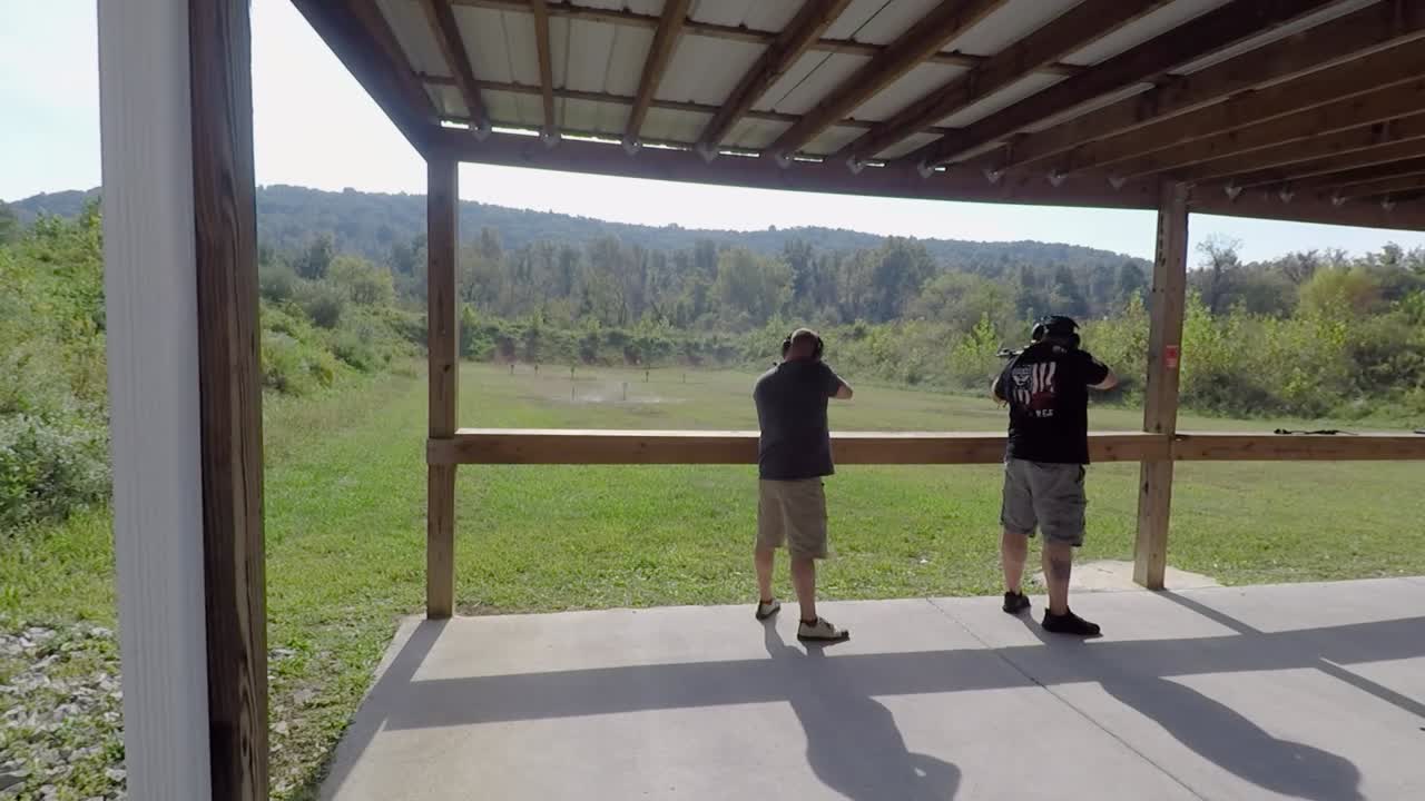 Two Men Gun Enthusiasts Practice Short Range Shooting on Public Gun Range