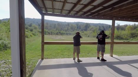 two men gun enthusiasts practice short range shooting on public gun range