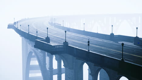 fog envelops a curving bridge creating an ethereal atmosphere