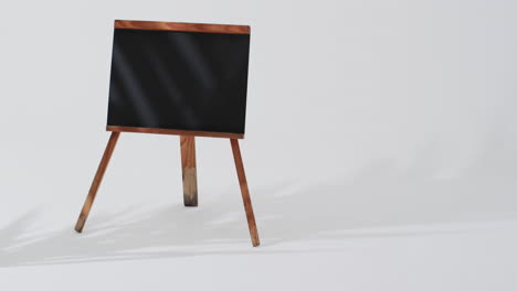 video de un letrero de pizarra en un soporte de madera con espacio de copia en un fondo blanco