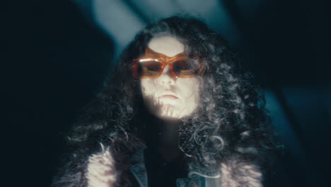 portrait of stylish woman in sunglasses in dark underpass at night