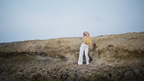 dance artist moving body sensually on rocks summer day. romantic girl dancing