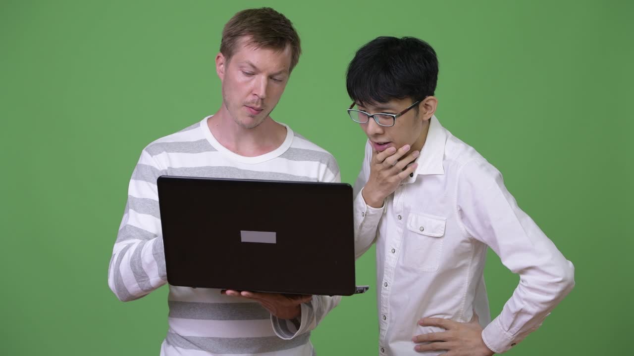 두 명의 젊은 다민족 사업가들이 함께 노트북을 가지고 회의를 하고 있습니다.