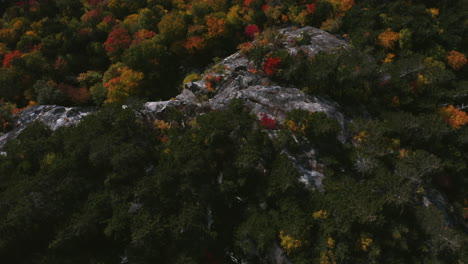 Vista-De-Pájaro-Del-Follaje-De-Otoño,-Volando-Desde-El-Acantilado-Revelado-En-La-Muesca-De-Evans,-Ubicado-En-Las-Montañas-Blancas-De-Maine