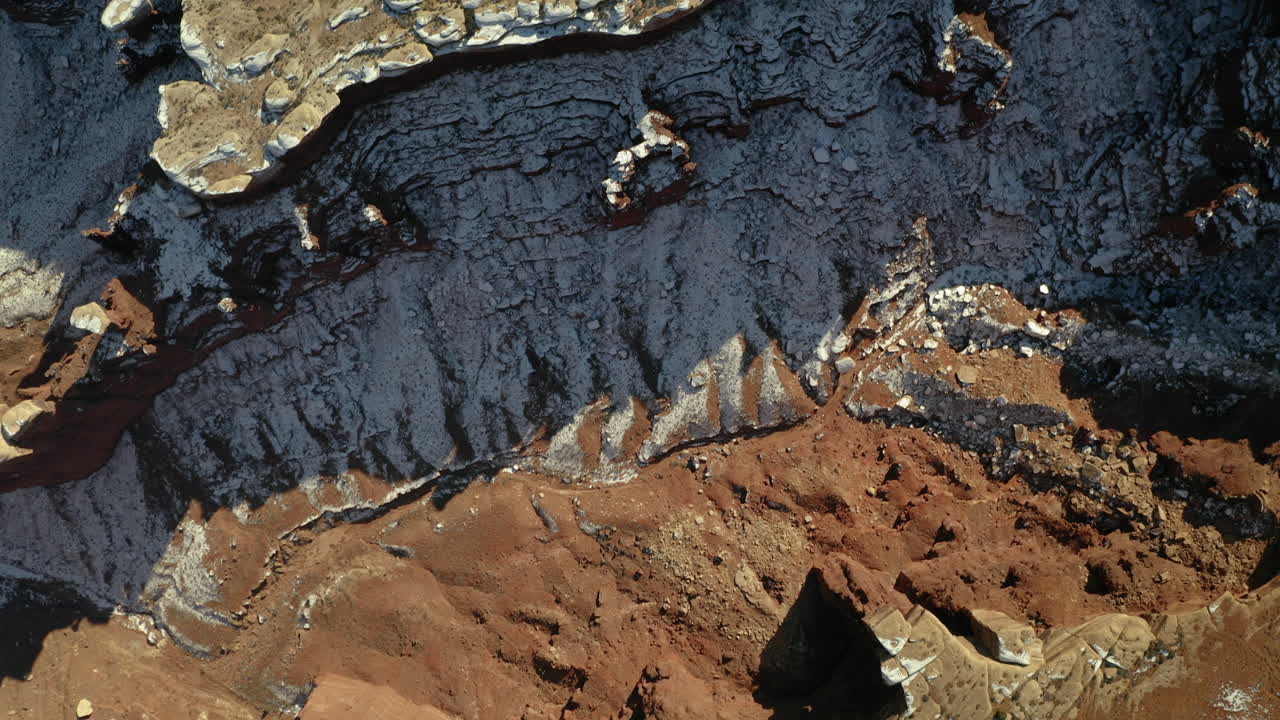 Aerial View of Arid Canyon Landscape with Red Rocks and White Formations