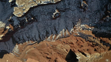 aerial view of arid canyon landscape with red rocks and white formations
