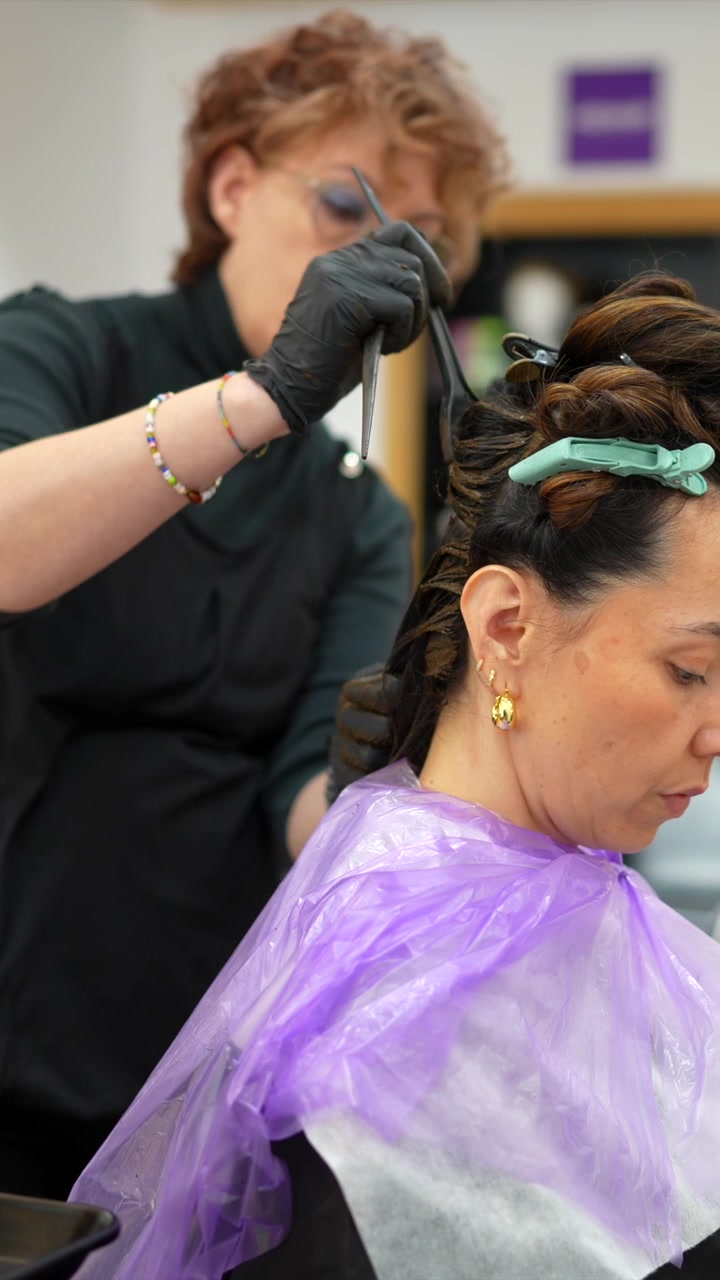 Cabeleireiro profissional aplicando tintura de cabelo na cliente no salão