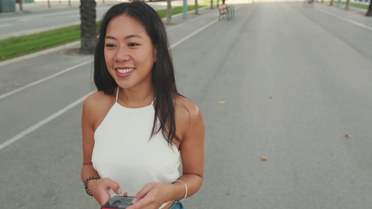 도시 거리에서 스마트폰을 사용하는 여성