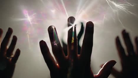 manos levantadas en oración con luz brillante