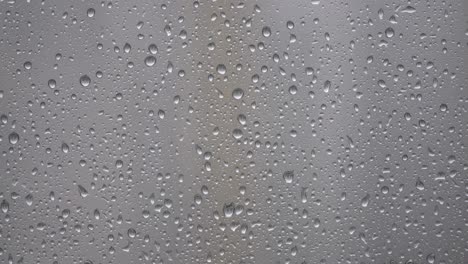 raindrops on blurry glass window - rainy day elements - close up