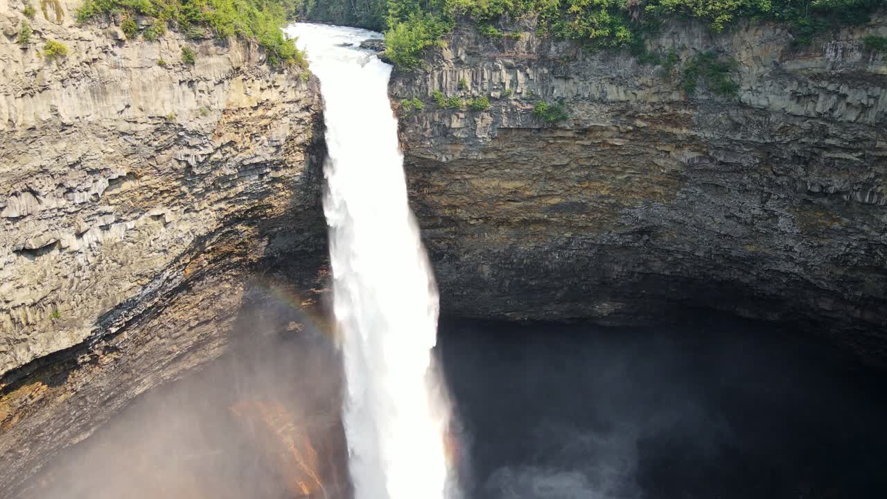 캐나다 브리티시 컬럼비아에 있는 웰스 그레이 주립 공원의 절벽 가장자리에 떨어지는 강력한 헬름켄 폭포