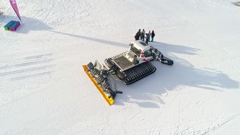 aerial shot of large snow pusher working in snowy mountains during sunlight