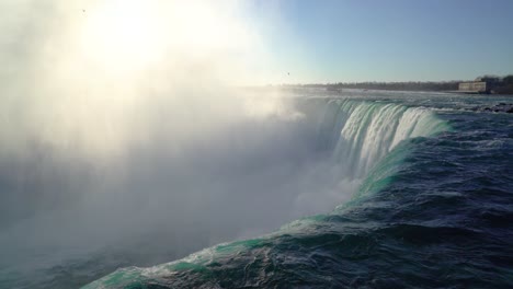 4k niagara falls water flowing into gorge at sunrise with birds flying through mist