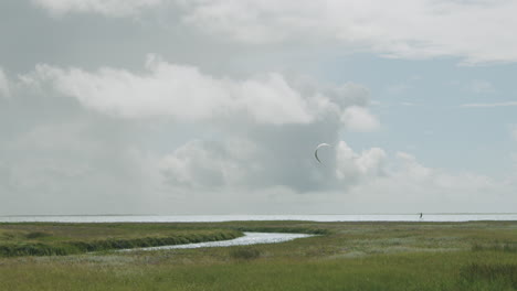 Epic wide slow-motion shot of a kite surfer on the horizon