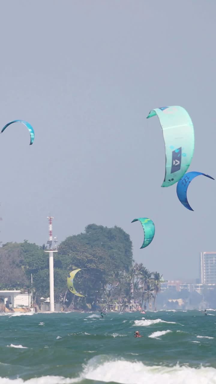 카이트 서퍼 들 은 바다 의 흔들리는 파도 를 가로질러 미끄러진다