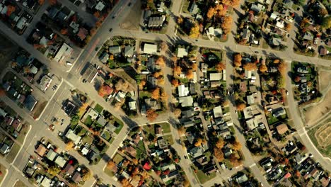 a cinematic, aerial view of the city of prince george downtown area, focusing on a winding, close-up residential area during the autumn - fall season