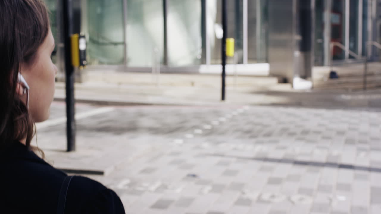 atractiva mujer de negocios viajera que usa un teléfono inteligente caminando en la ciudad de londres