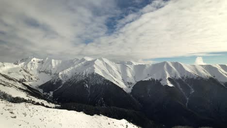 Snow-capped-Piscu-Negru-and-Mesteacanu-peaks-under-a-textured-sky-in-Fagaras-Mountains