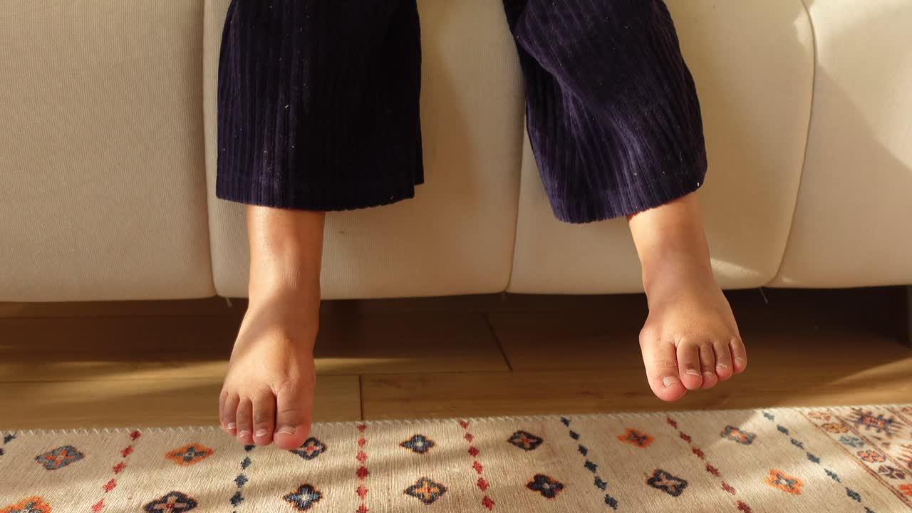 소파 에 앉아 있는 맨발 의 아이