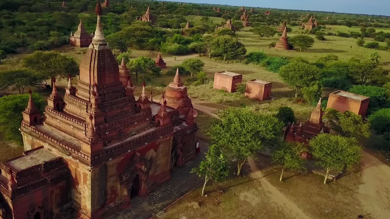 A stunning aerial reveal showcasing a landscape filled with dozens of ancient temple pagodas in Bagan, Myanmar. Perfect for cultural, travel, and historical content highlighting this sacred site.