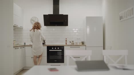 Mujer-Joven-Feliz-Haciendo-Café-En-La-Cocina.-Señora-Sonriente-Recibiendo-Mensaje.