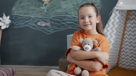 smiling girl hugging teddy bear