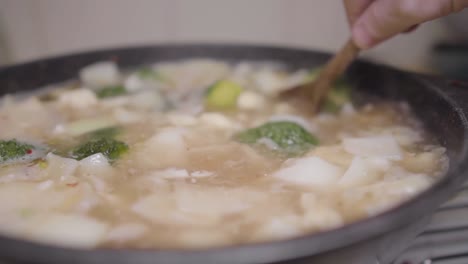 Moviendo-Mezclando-Y-Removiendo-Verduras-Picadas-Cocinando-En-Caldo-Con-Cuchara-De-Madera-Receta-Auténtica-Chef-Casero-Rústico