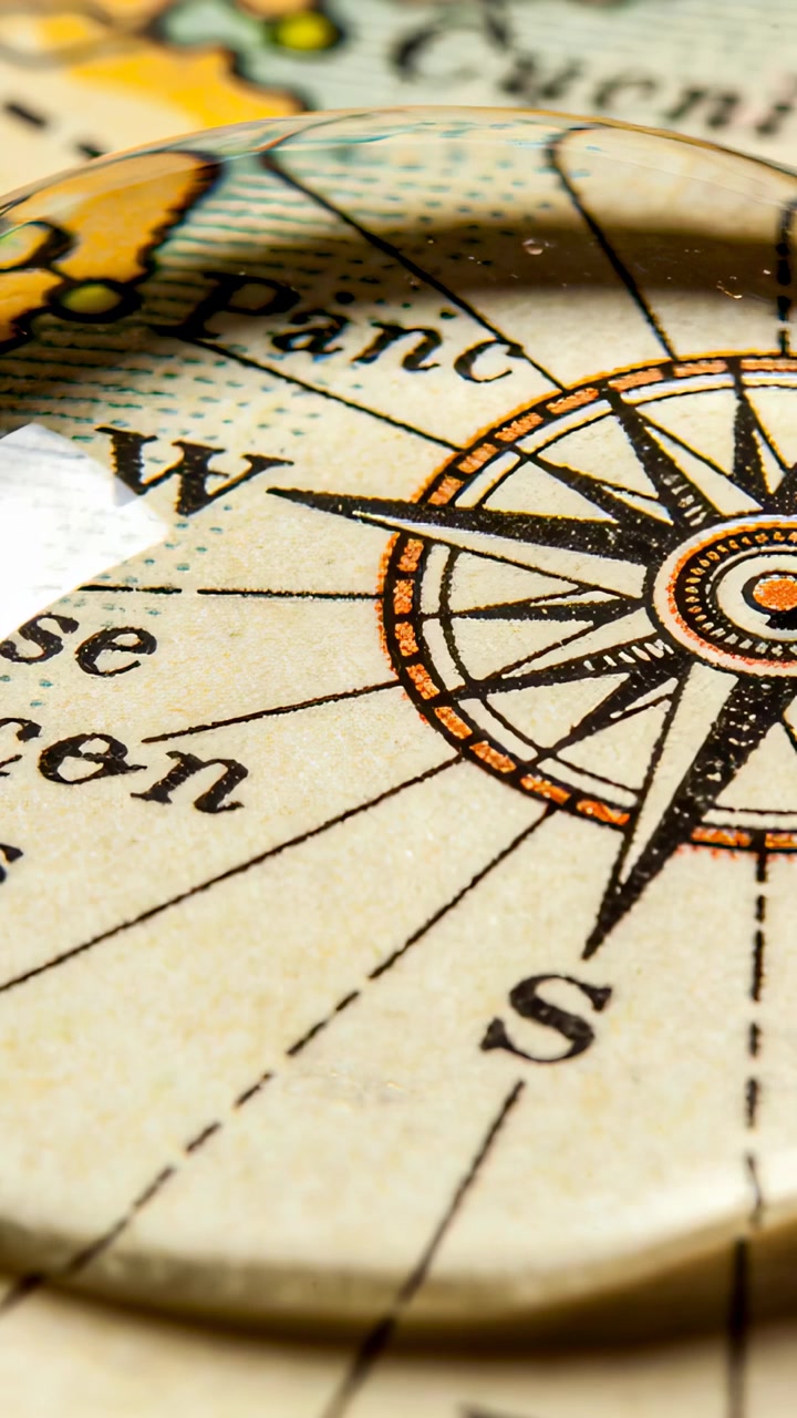 Vertical video: Shifting cabochon with slight camera shift revealing compass rose W and S on map