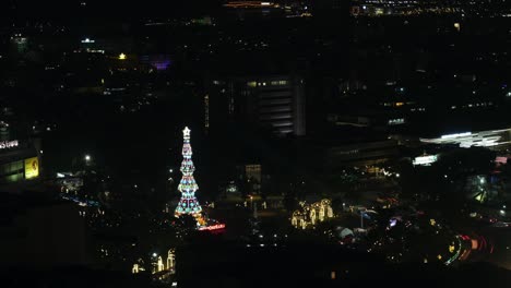 motion timelapse of traffic at the fuente osmeña circle during nighttime with colorful christmas tree sparkling in the dark in cebu city, philippines