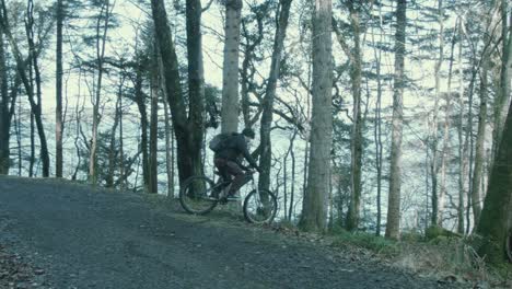 youth cycles towards edge of path and down hill