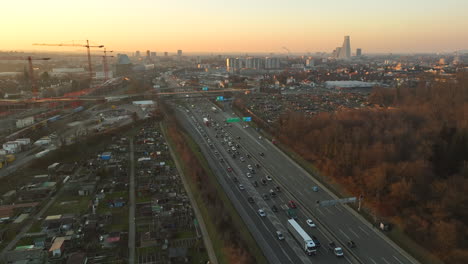 cars and truck driving slowly in a traffic jam on the highway ring of basel during sunset