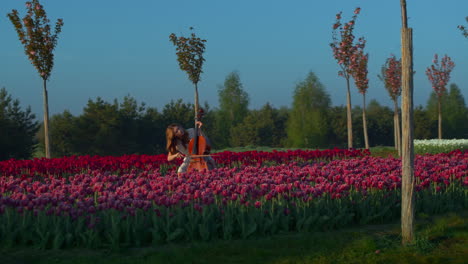 niña tocando un instrumento musical en el campo de flores. mujer inspirada creando música.