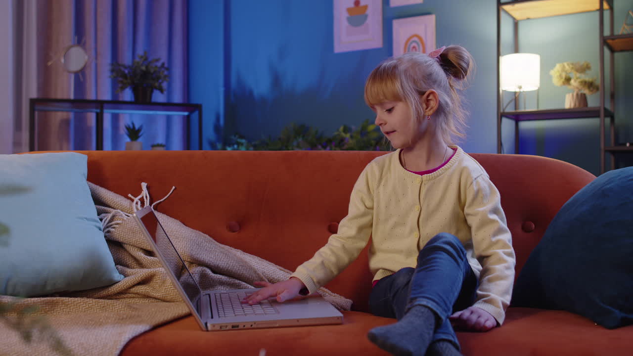 niña pequeña de escuela que usa una computadora portátil aprende a leer lecciones de educación en línea sola en casa