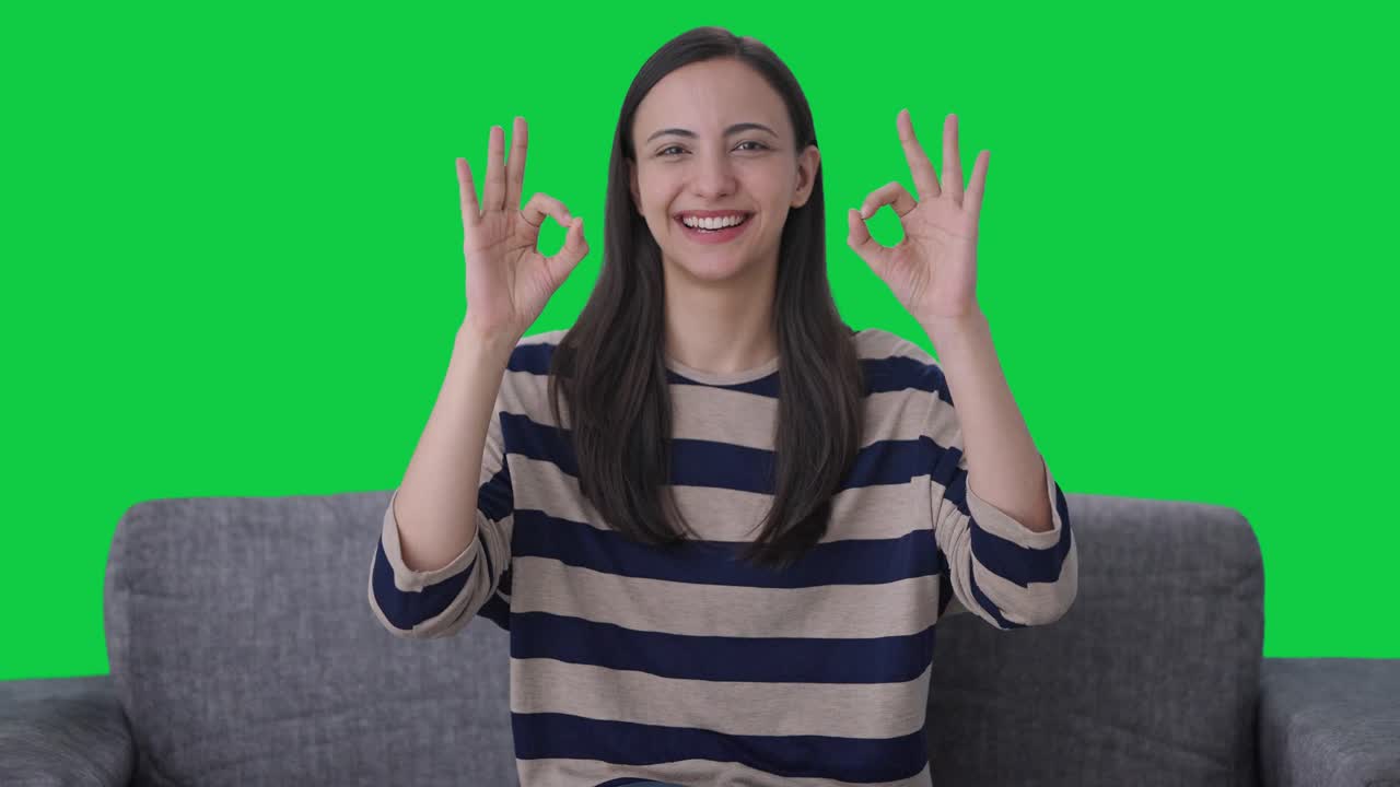 Ragazza indiana felice che mostra il segno dell'ok Green screen