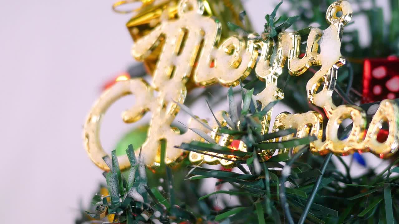 색 배경에 고립 된 새해 2020 년을 위해 baubles, 조명 및 작은 선물 선물로 장식 된 크리스마스 트리.