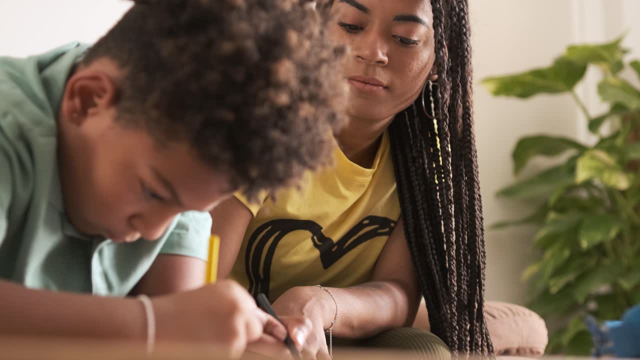 An adult woman helping a child with schoolwork
