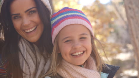 Female-parents-and-daughter-in-a-forest-looking-to-camera