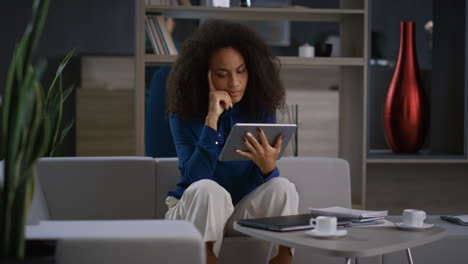 mujer afroamericana usando una tableta. persona de negocios enfocada en la oficina.