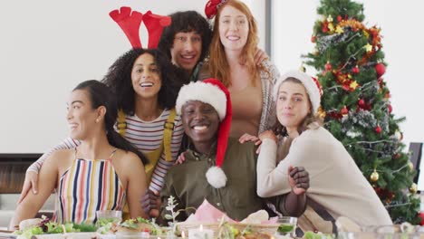 Portrait-of-happy-group-of-diverse-friends-sitting-at-table-and-eating-dinner-together